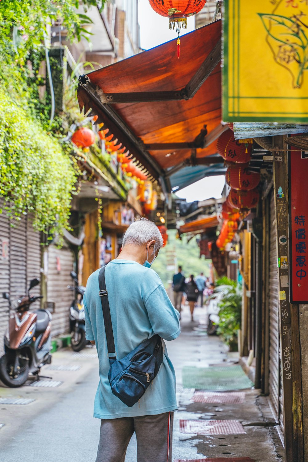 a man standing on the side of a street talking on a cell phone