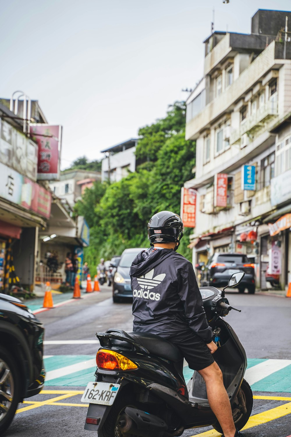 a man sitting on a scooter on a city street