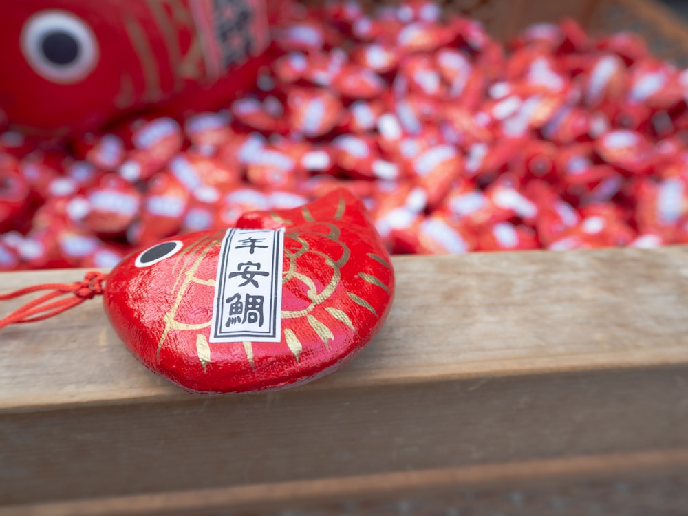 a close up of a red object on a wooden surface