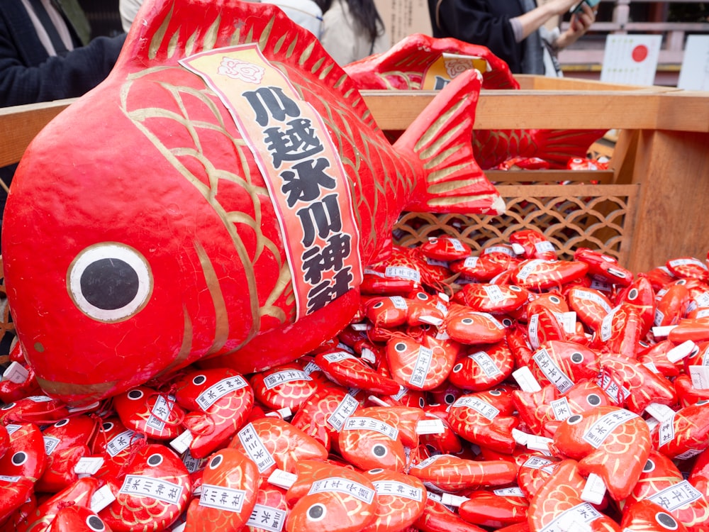 a large red fish sitting on top of a pile of candy