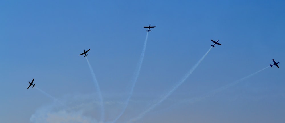 a group of airplanes flying through a blue sky