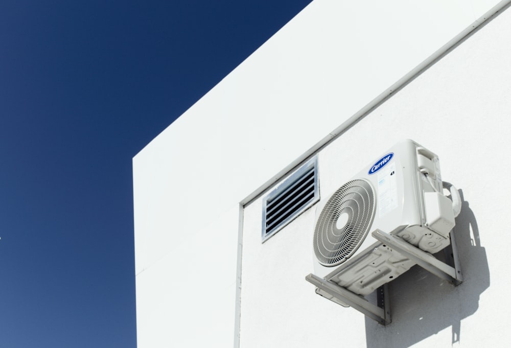 a white air conditioner mounted to the side of a building