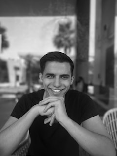 a black and white photo of a smiling man