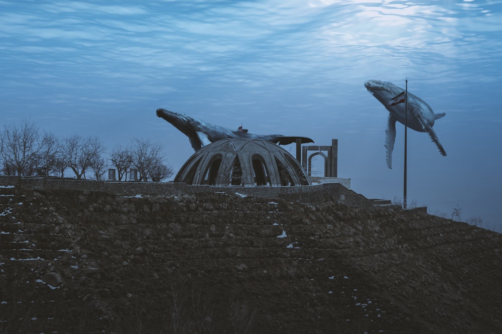 a statue of a man laying on top of a building under water