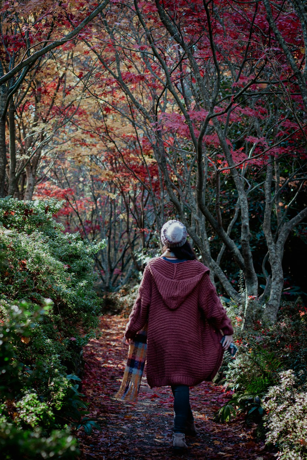 a woman walking down a path in the woods
