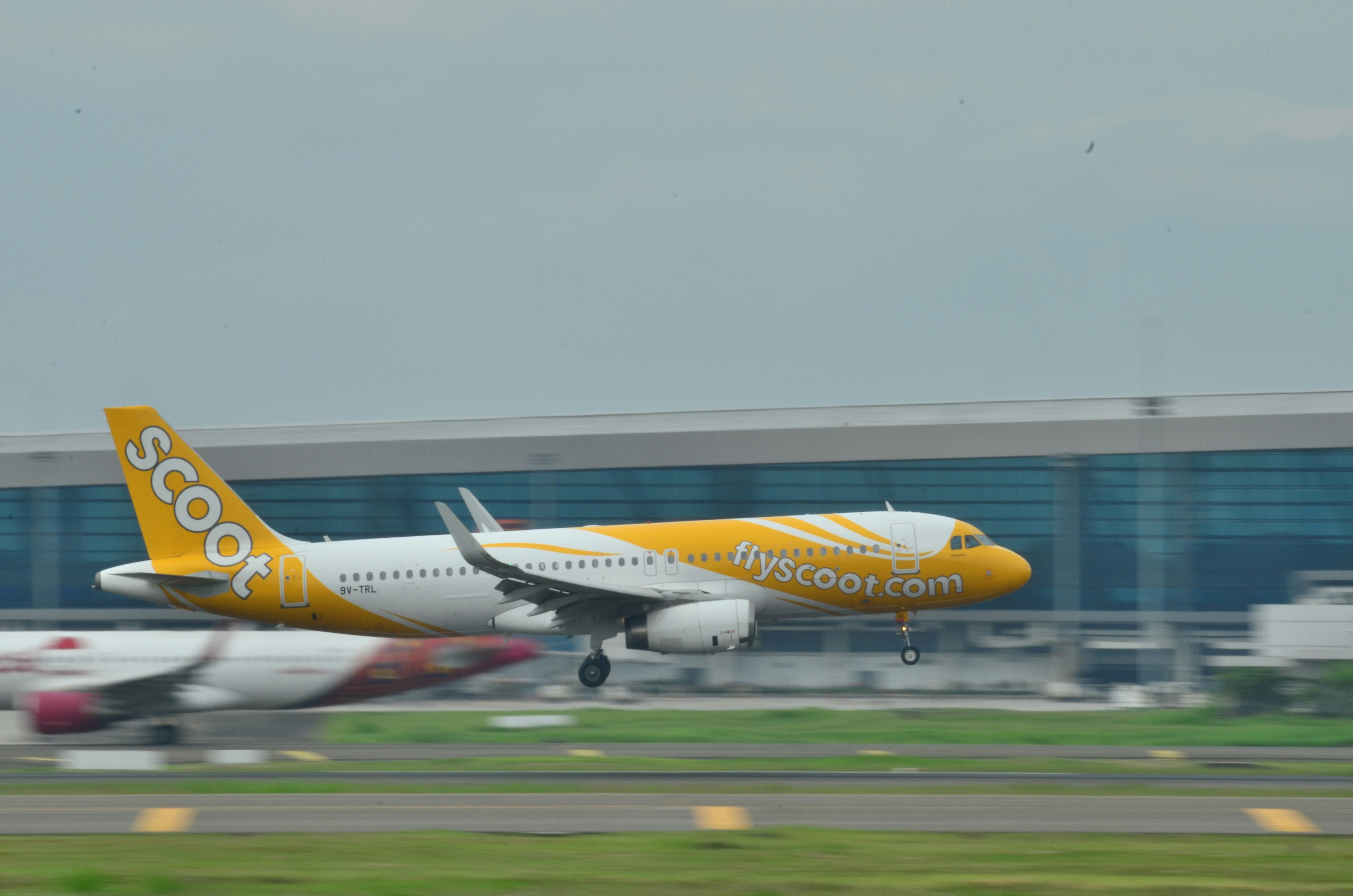 a yellow and white airplane taking off from an airport, a320 final approach 