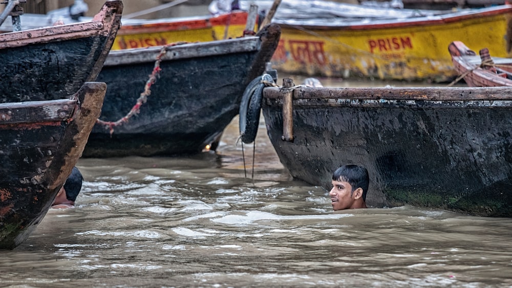 a man in a body of water next to several boats