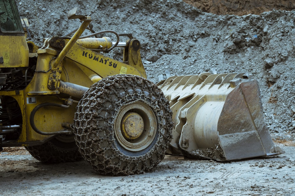 a yellow bulldozer sitting on top of a pile of dirt