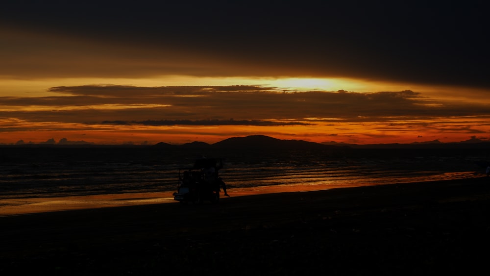 a motorcycle is parked on the beach at sunset