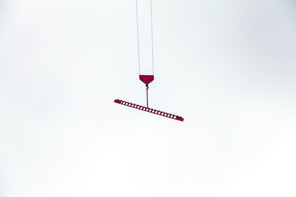 a red object being lifted by a crane