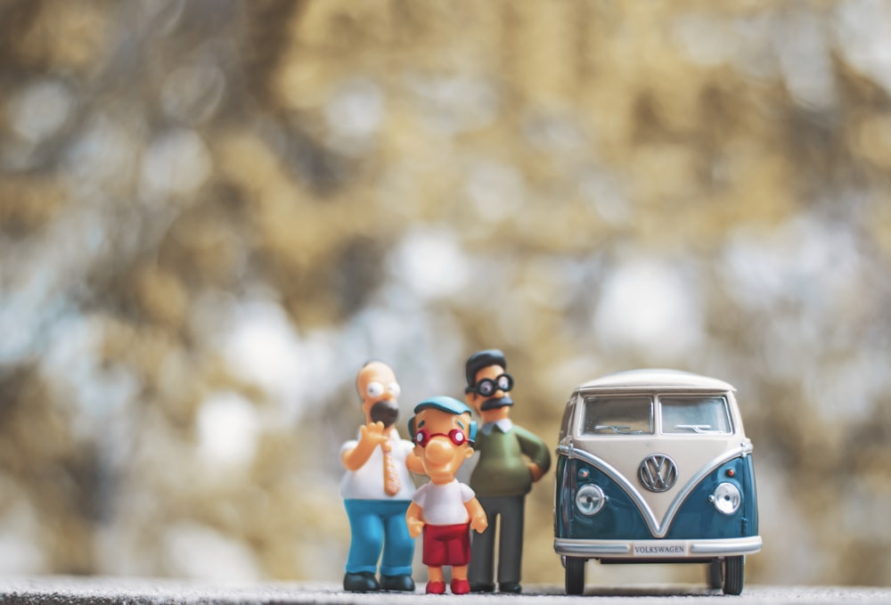 Figurines miniatures de personnes debout à côté d’un bus VW