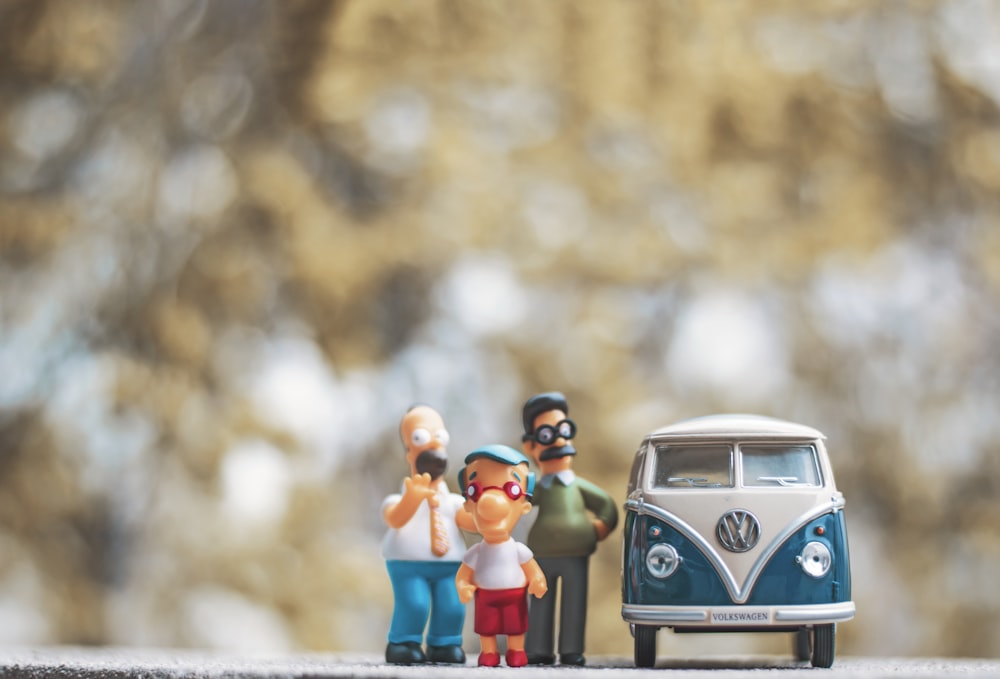 Figuras en miniatura de personas de pie junto a un autobús VW