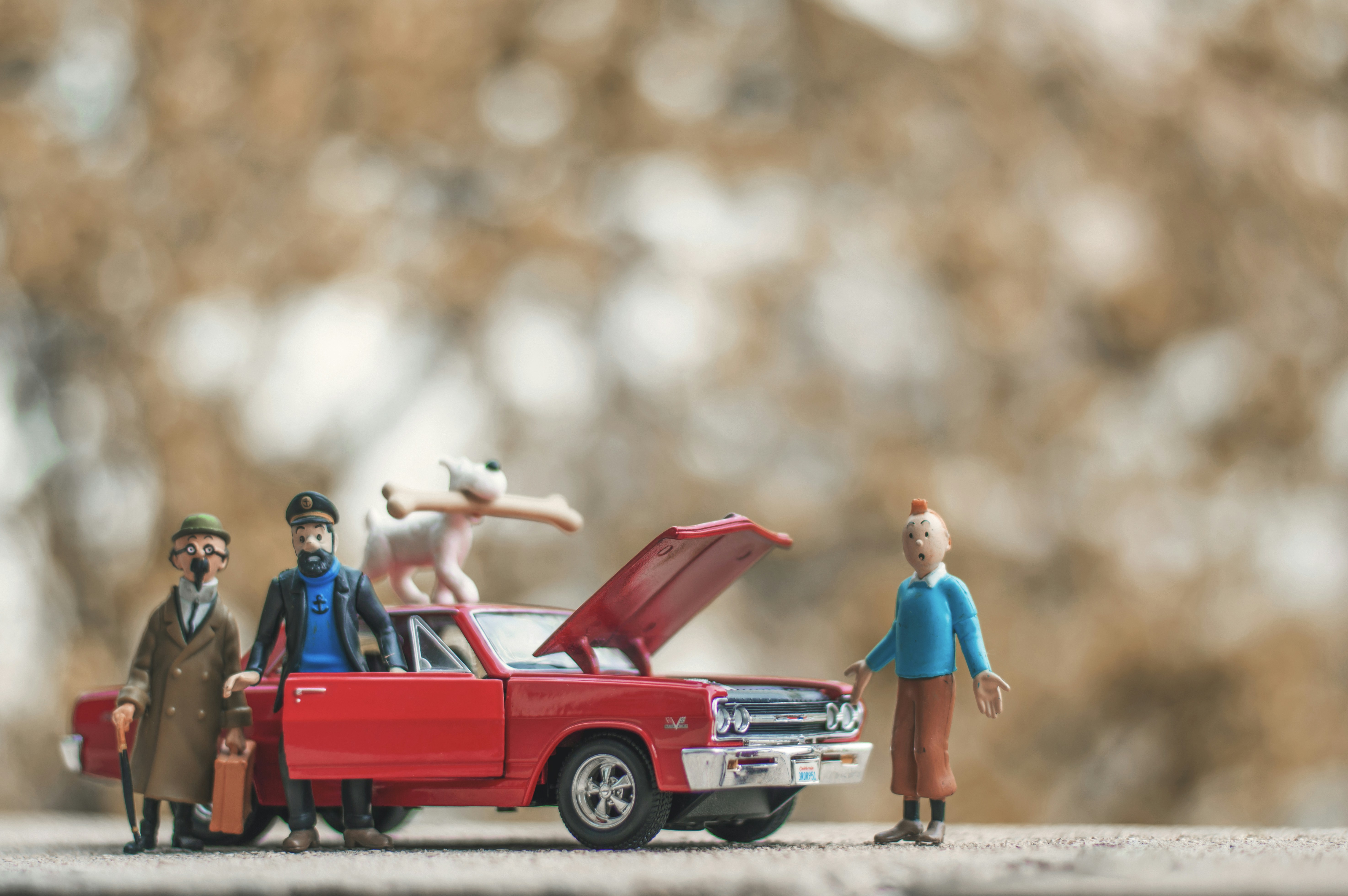 a group of toy people standing next to a red truck
