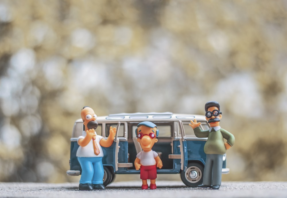a group of figurines are standing in front of a van