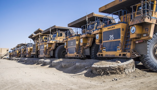 a row of large yellow trucks parked next to each other