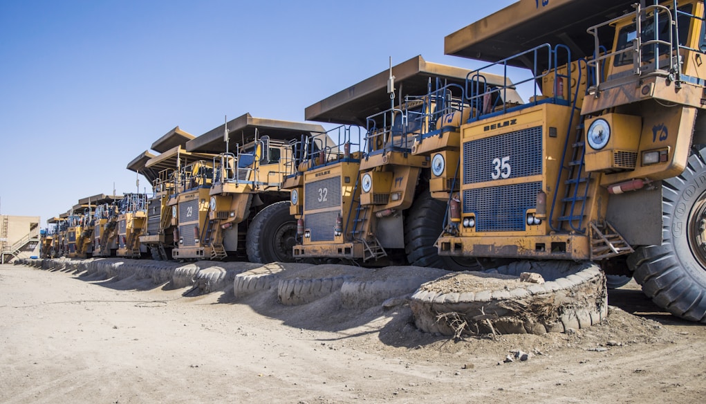 a row of large yellow trucks parked next to each other