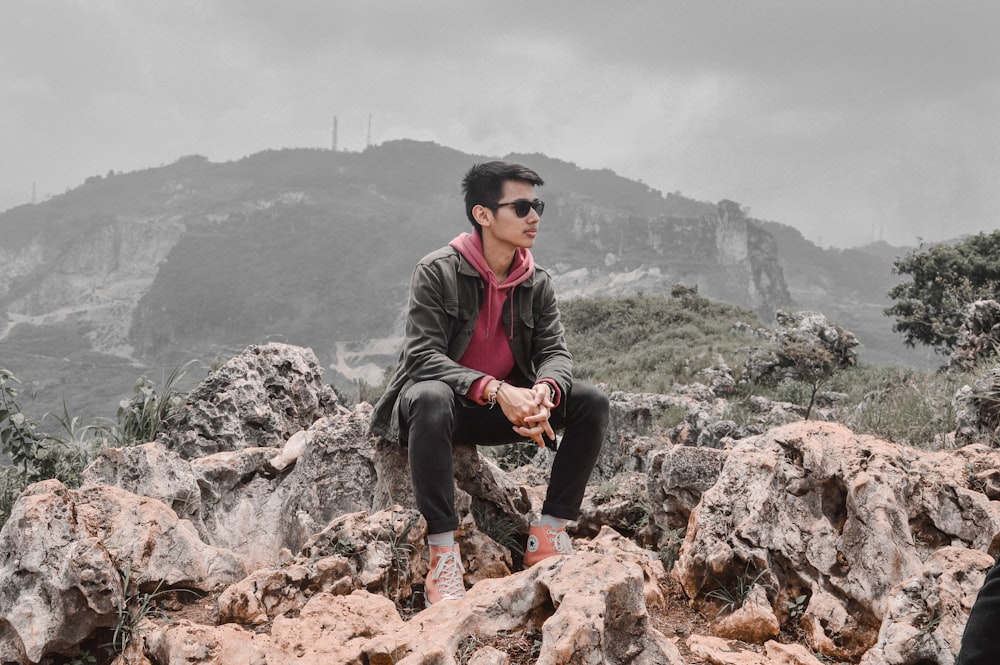 a man sitting on top of a pile of rocks