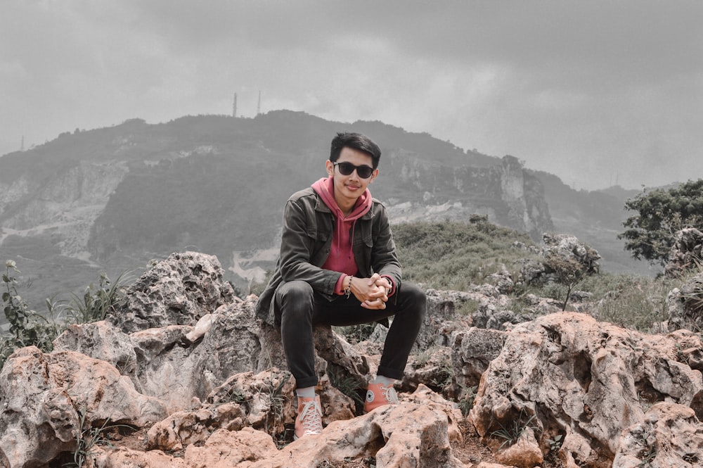 a man sitting on top of a pile of rocks