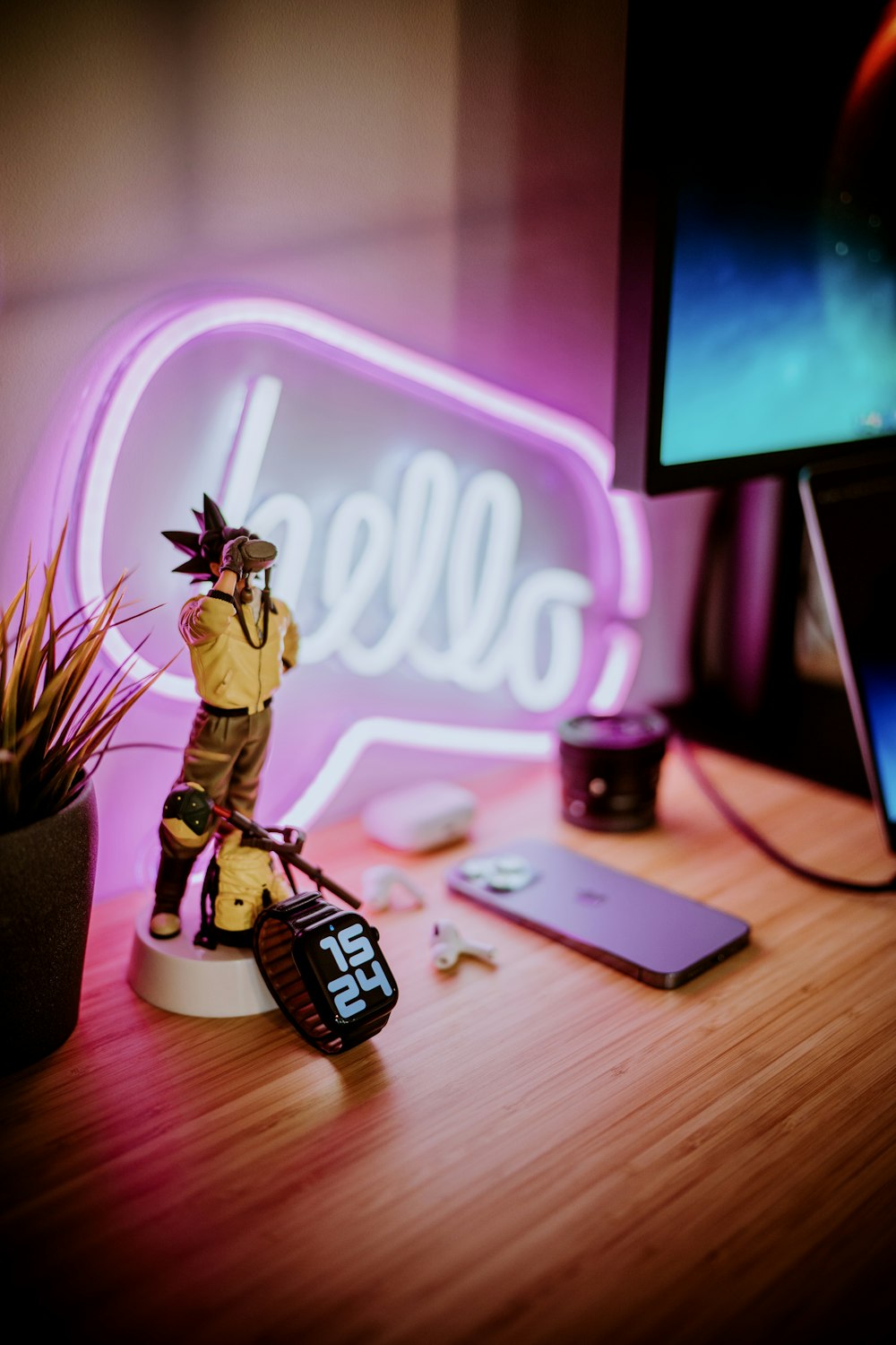 a desk with a cell phone and a neon sign