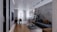A modern and stylish living room with an open concept design. The space includes a comfortable dark gray sectional sofa with brown cushions, a low rectangular coffee table with a decorative item on top, and a lush green plant beside the sofa. The room has a wooden floor in the foreground, transitioning to a tiled floor towards the back. A dining area with a sleek table and chairs can be seen near large windows adorned with sheer white curtains, allowing natural light to fill the space. Above, modern pendant lights hang from the ceiling, and shelves with decorative items are mounted on the far wall.