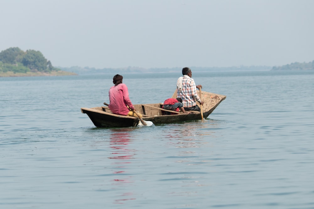 two people sitting in a small boat on the water