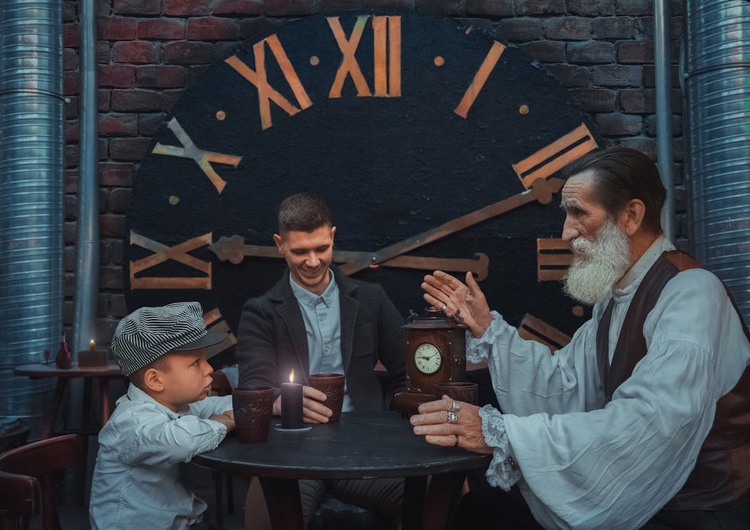 a group of people sitting around a table with a clock on it, Inspirational story from elder to younger in fantasy mediev