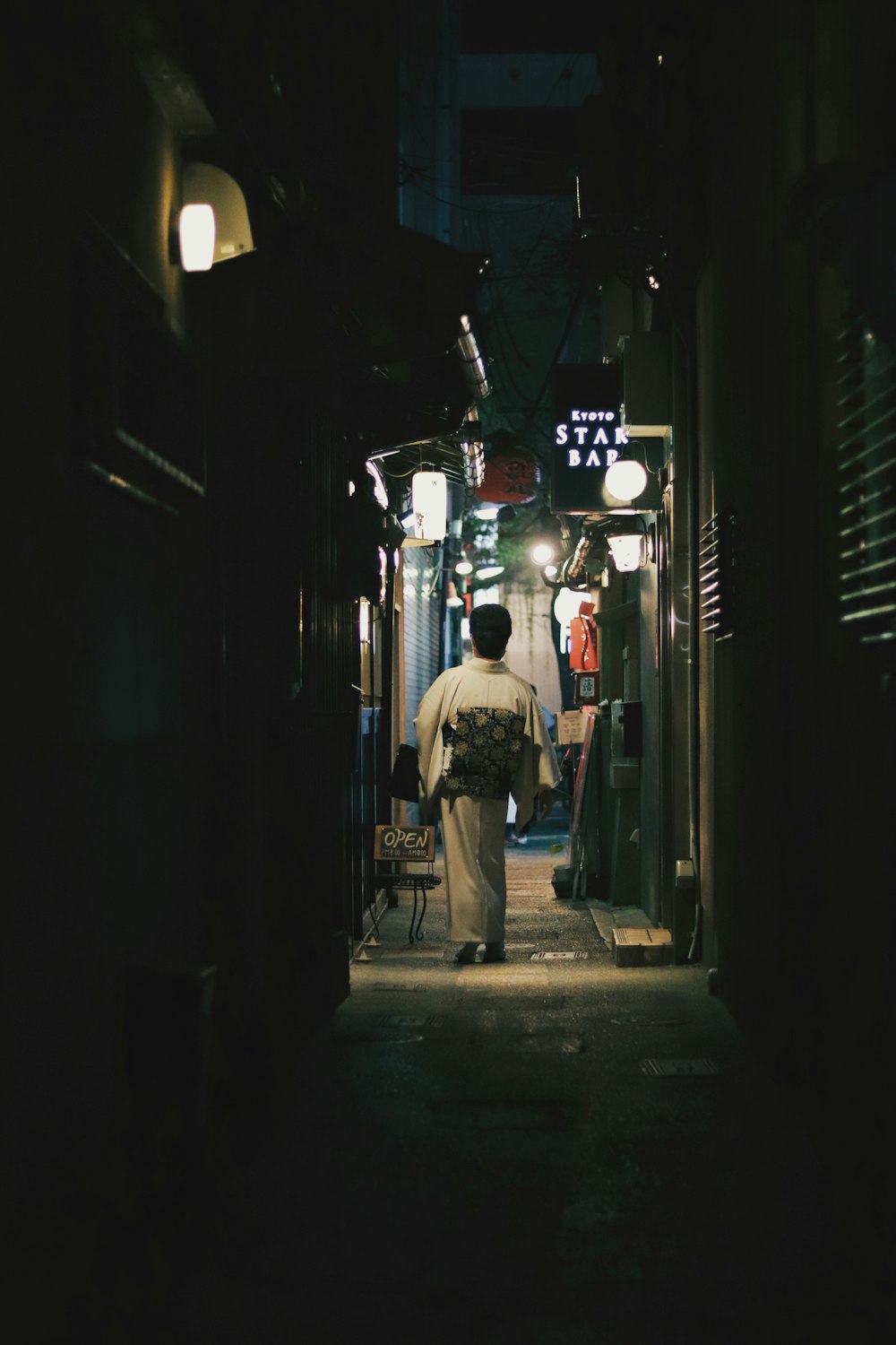 a man walking down a dark alley way