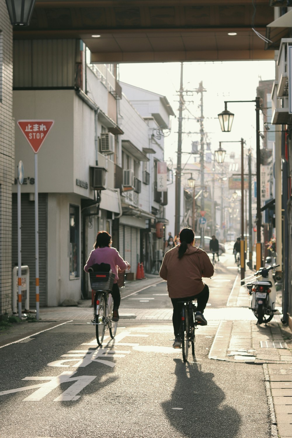 a couple of people riding bikes down a street