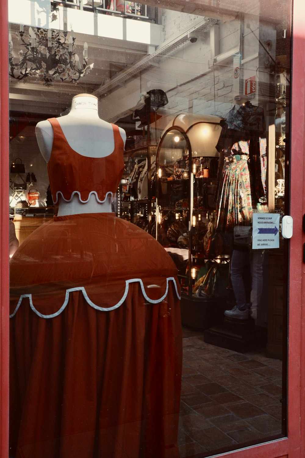 a mannequin dressed in a red dress in a shop window