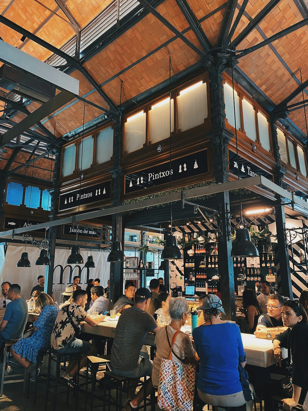 a group of people sitting at tables in a restaurant