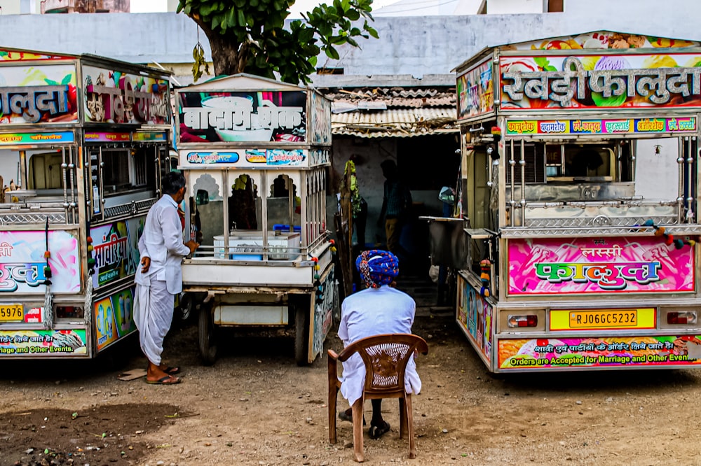 a man sitting in a chair in front of a food truck