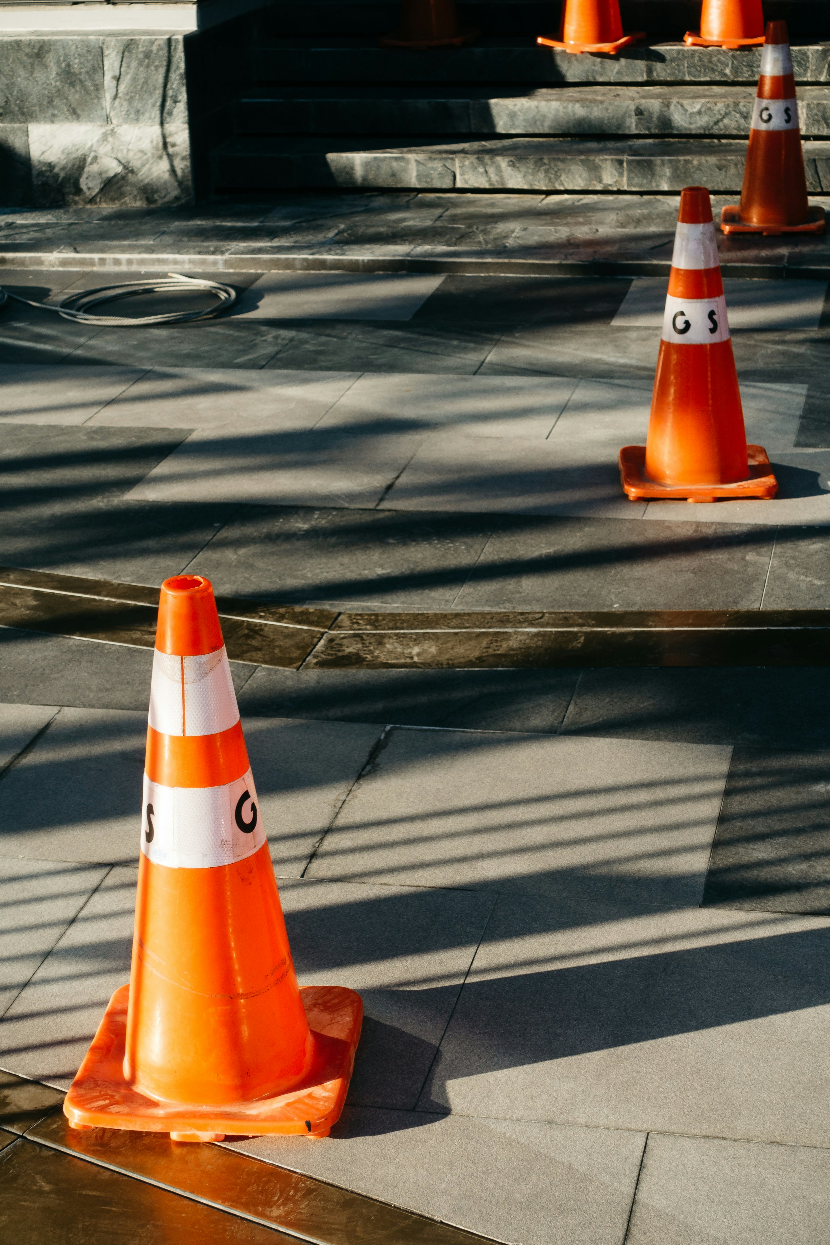 Cônes de signalisation orange assis sur un trottoir à côté de marches