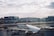 An airplane from Turkish Airlines is parked at an airport gate, surrounded by various ground service vehicles. The terminal building stretches across the background under a partly cloudy sky.