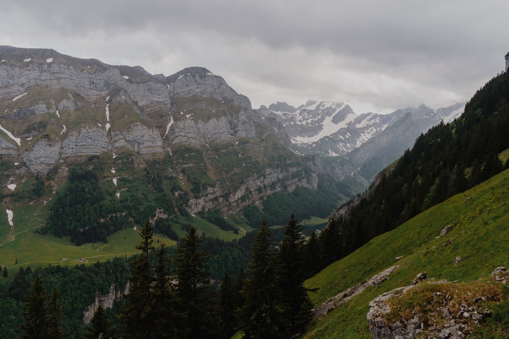 a view of a mountain range with trees and mountains in the background