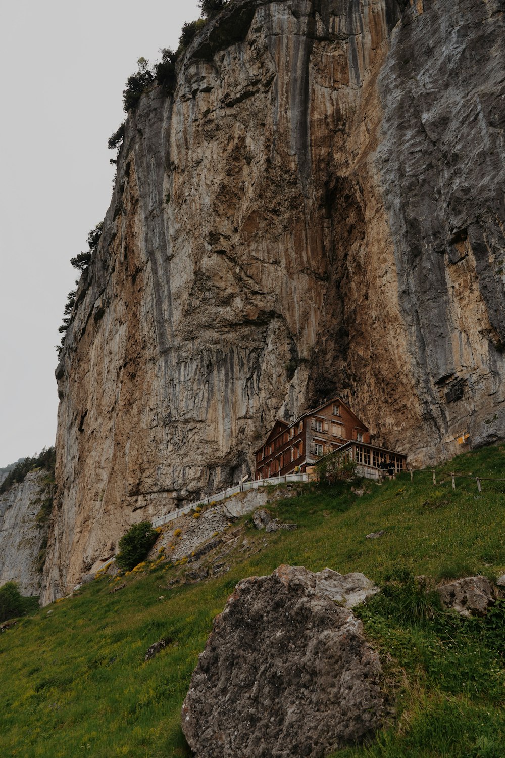 a large rock cliff with a house on top of it