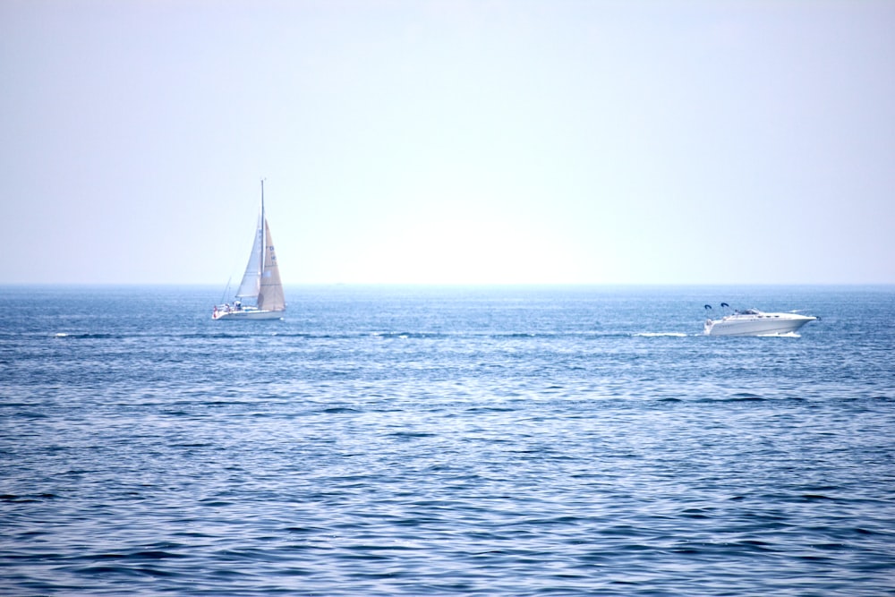 a sailboat and a boat in the ocean