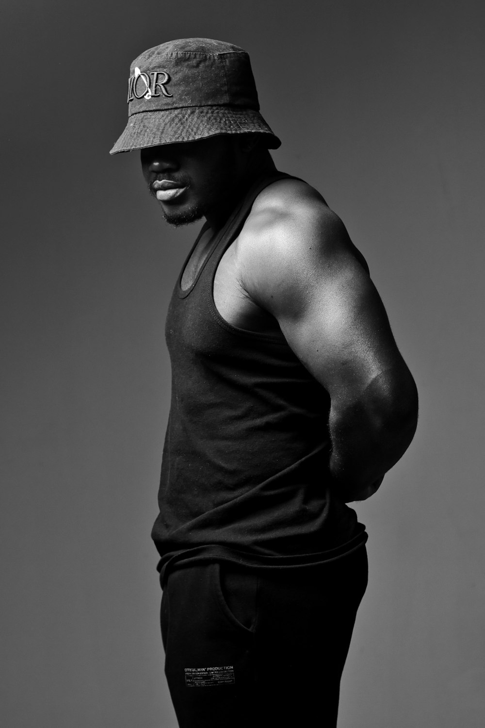 um homem usando um chapéu em pé em uma foto em preto e branco