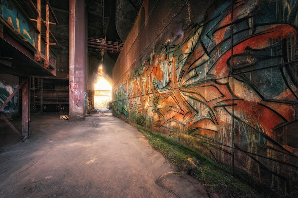 a wall covered in graffiti next to a building