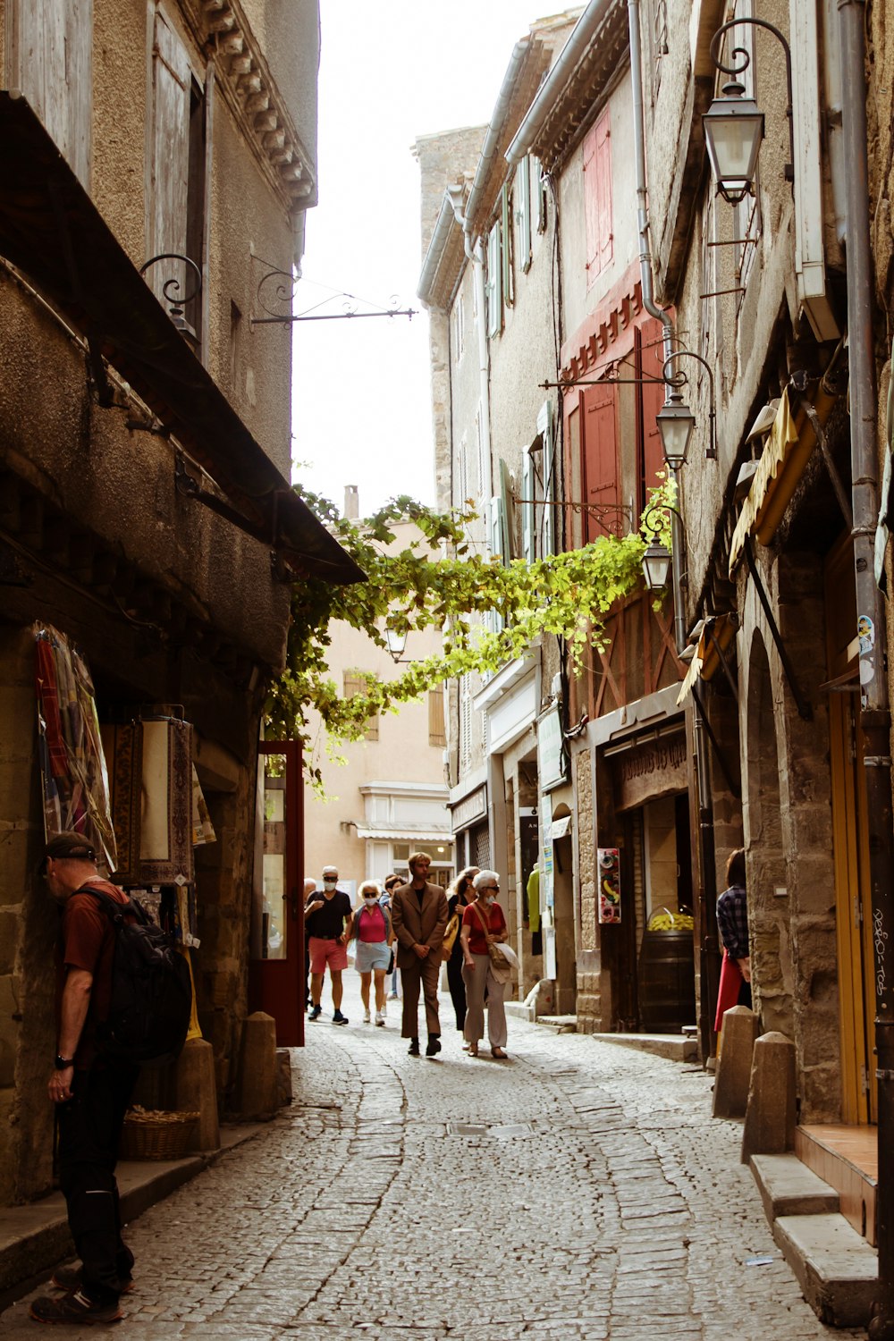 a group of people walking down a cobblestone street