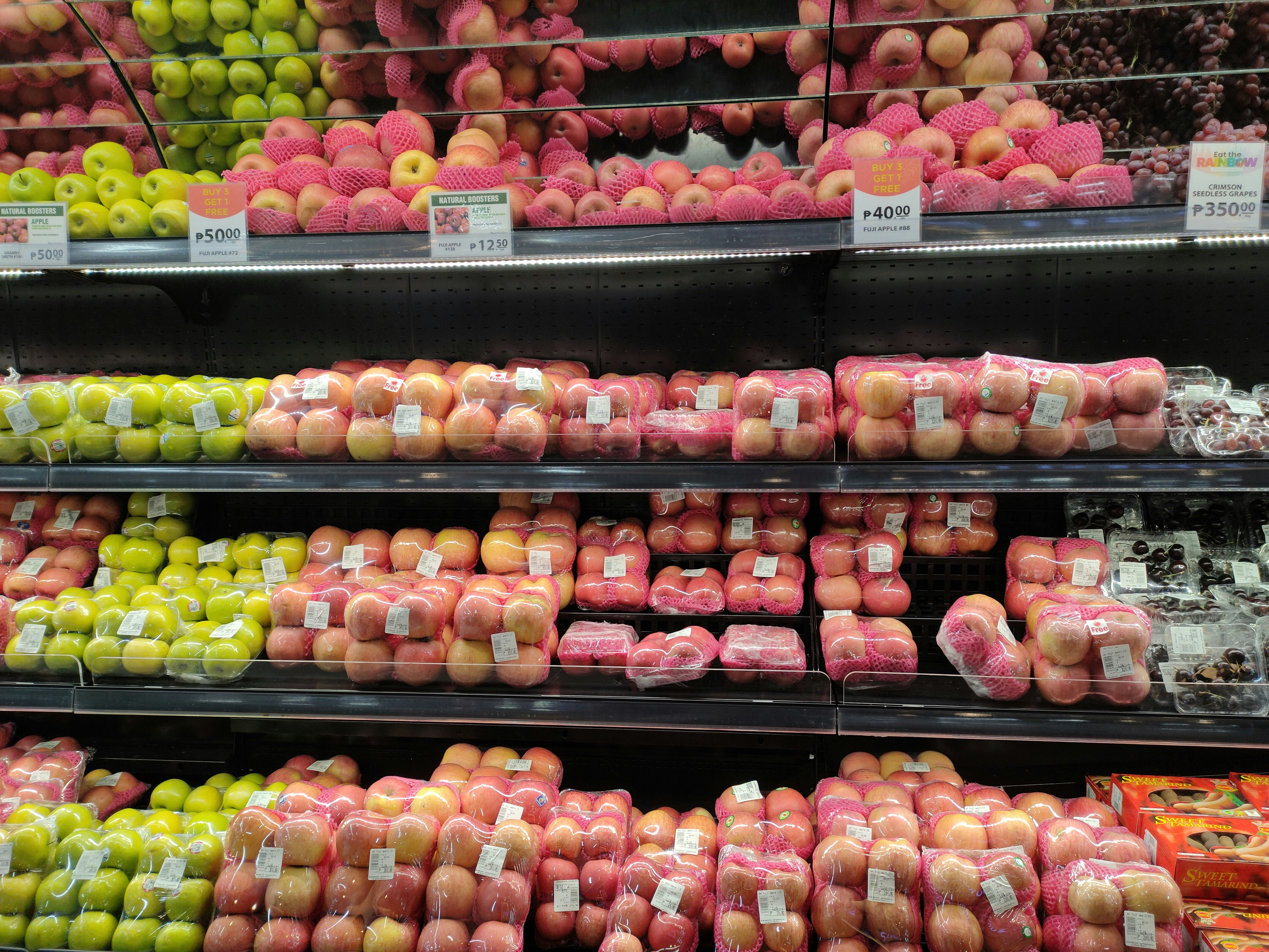 a display in a grocery store filled with lots of apples