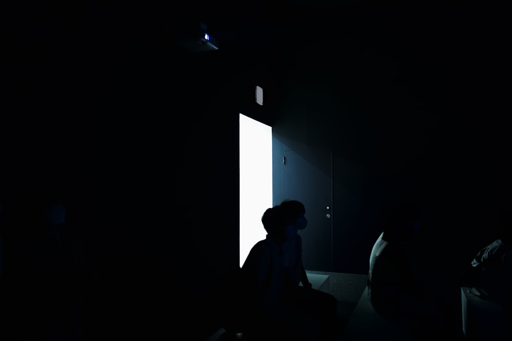 a person standing in a dark room with a door open