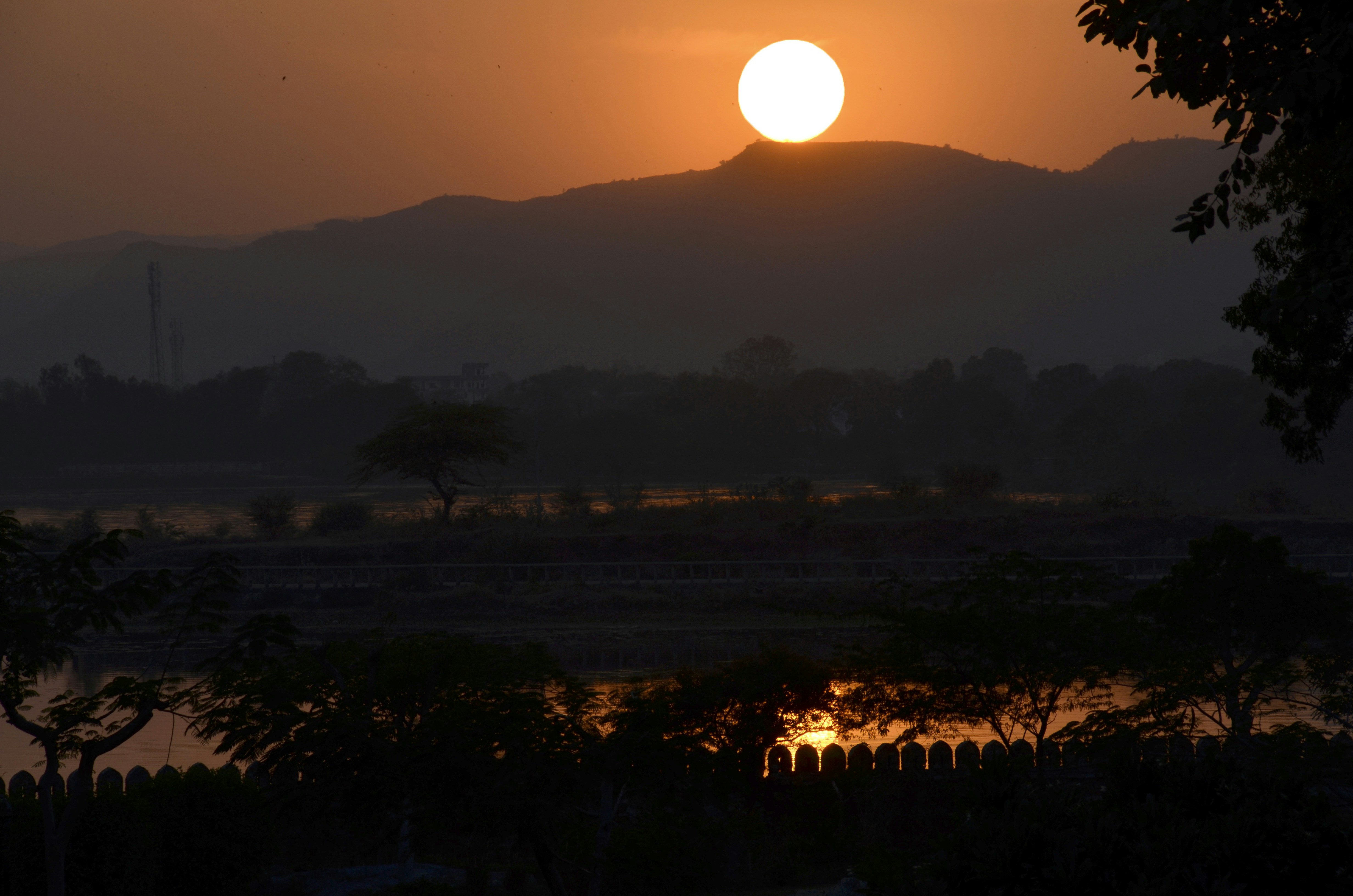 the sun is setting over a mountain range