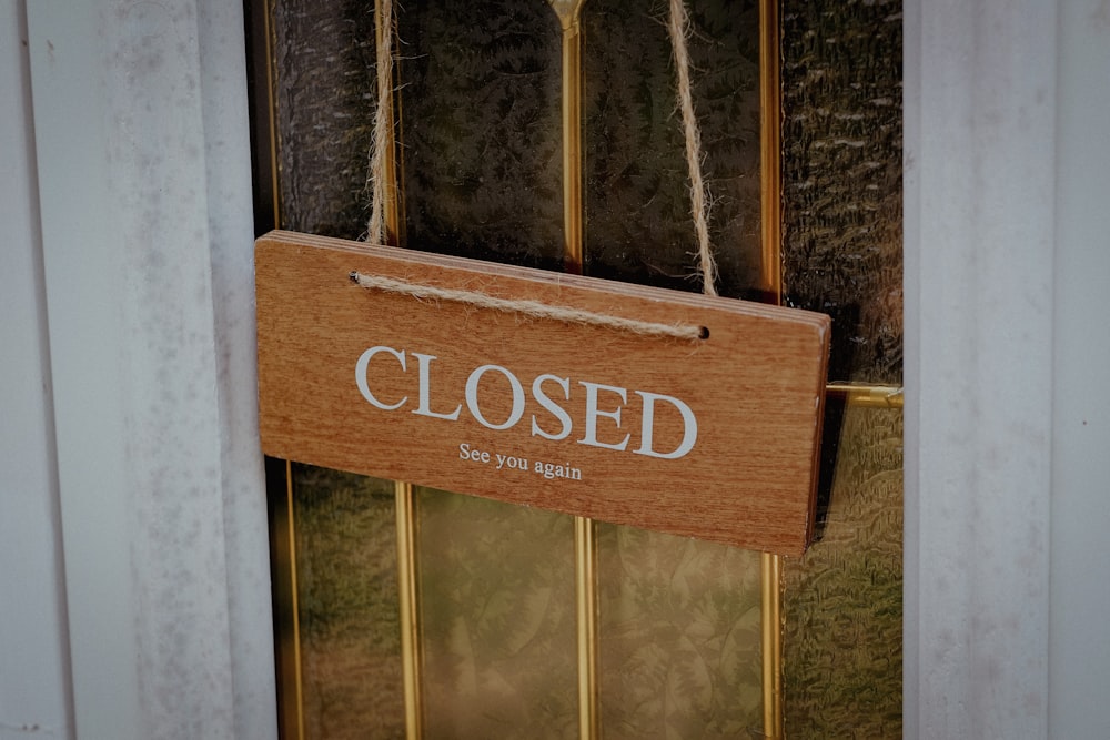 a closed sign hanging from the side of a door