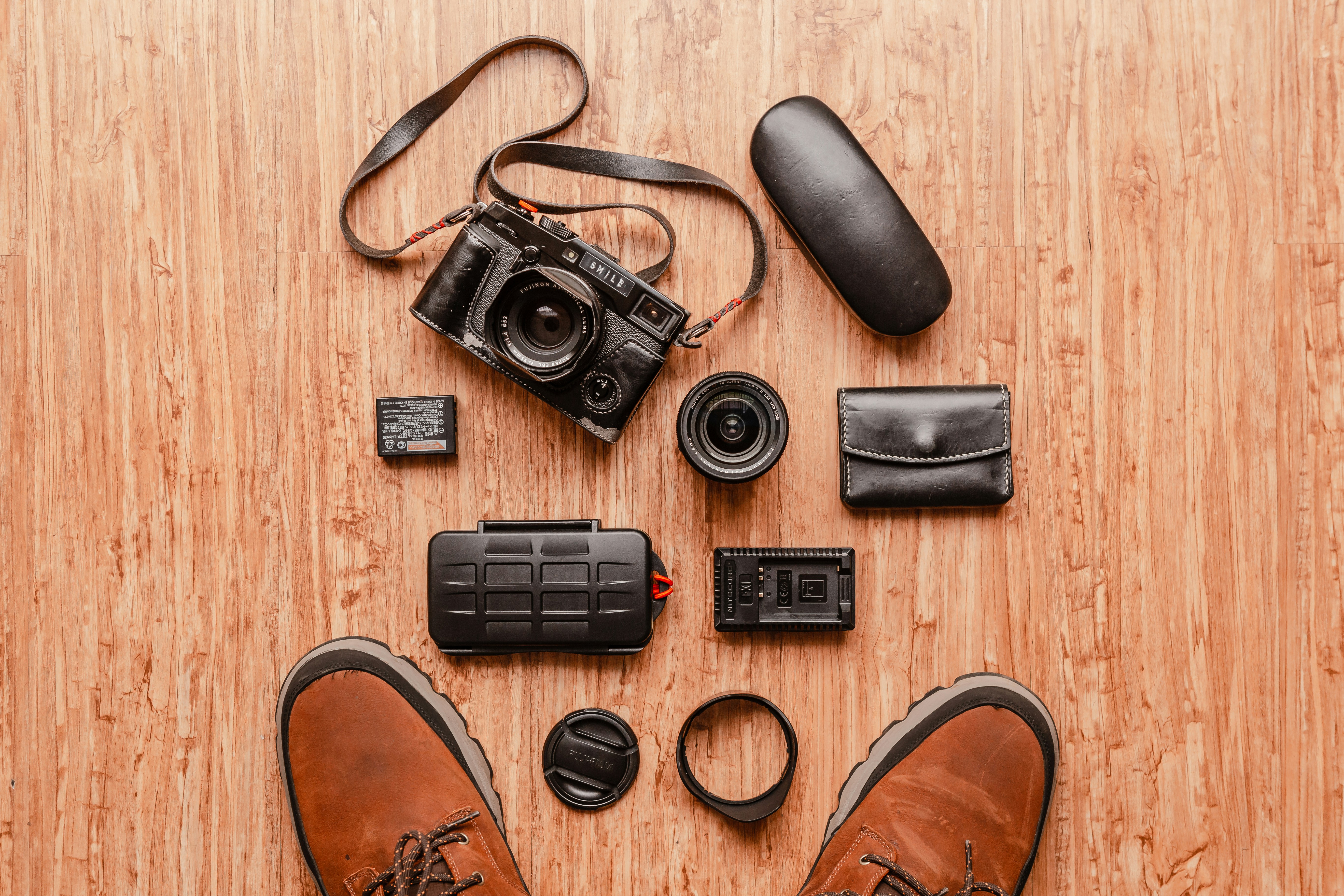 a pair of shoes, a camera, and other items laid out on a wooden, Daily rangefinder camera
