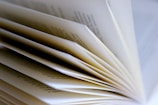 Close-up of hands flipping through pages of a hardcover book