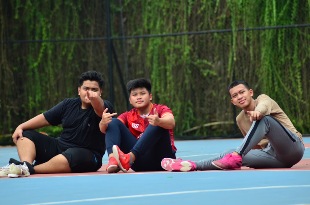 a group of people sitting on top of a tennis court