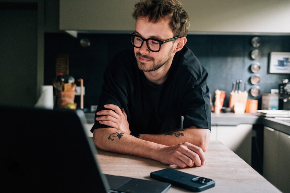 a man sitting at a table with a laptop