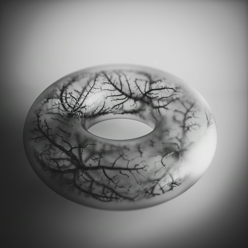 a black and white photo of a donut with trees on it