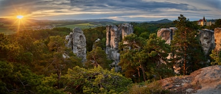 the sun is setting over the rocky landscape