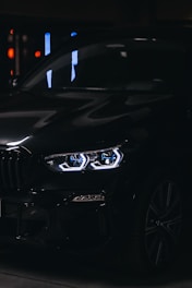 Close-up of a sleek black customized car accessory glowing subtly under neon green lighting.